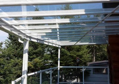 Side view of all glass patio cover on raised deck