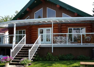 Large all glass patio cover and glass railings on log house