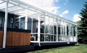 Glass walled and glass roofed sunroom and glass patio cover over hot tub
