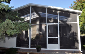 White aluminum screen room with peaked roof and skylights