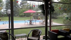View of a pool from screen room with aluminum posts
